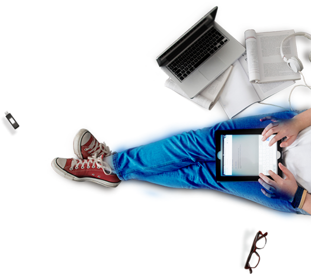 A man sitting and working on a laptop and tab